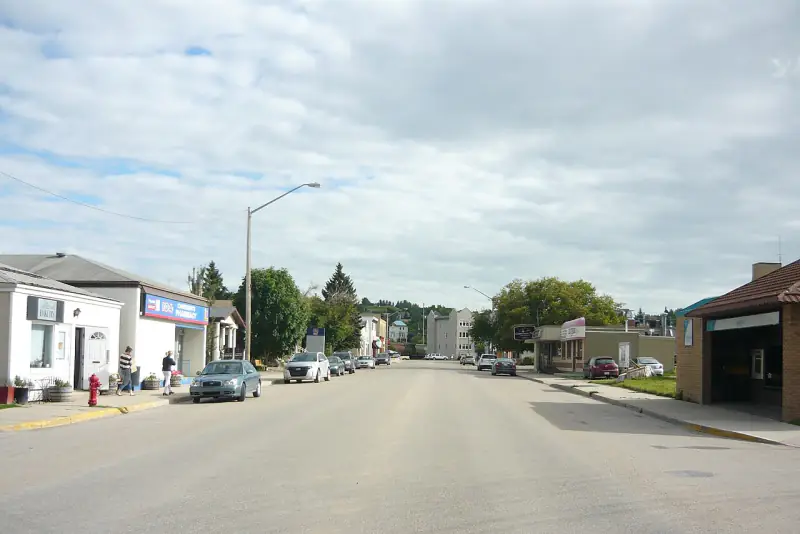 Main street in Lumsden with shops and the valley hillside rising behind town