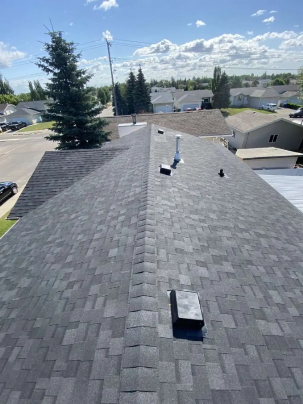 A completed replacement seen from the ridge, with new roof vents in place, Saskatchewan