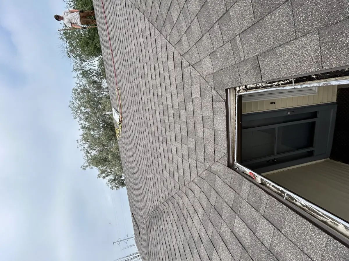 A crew member up at the ridge partway through a re-roof, Saskatoon, SK